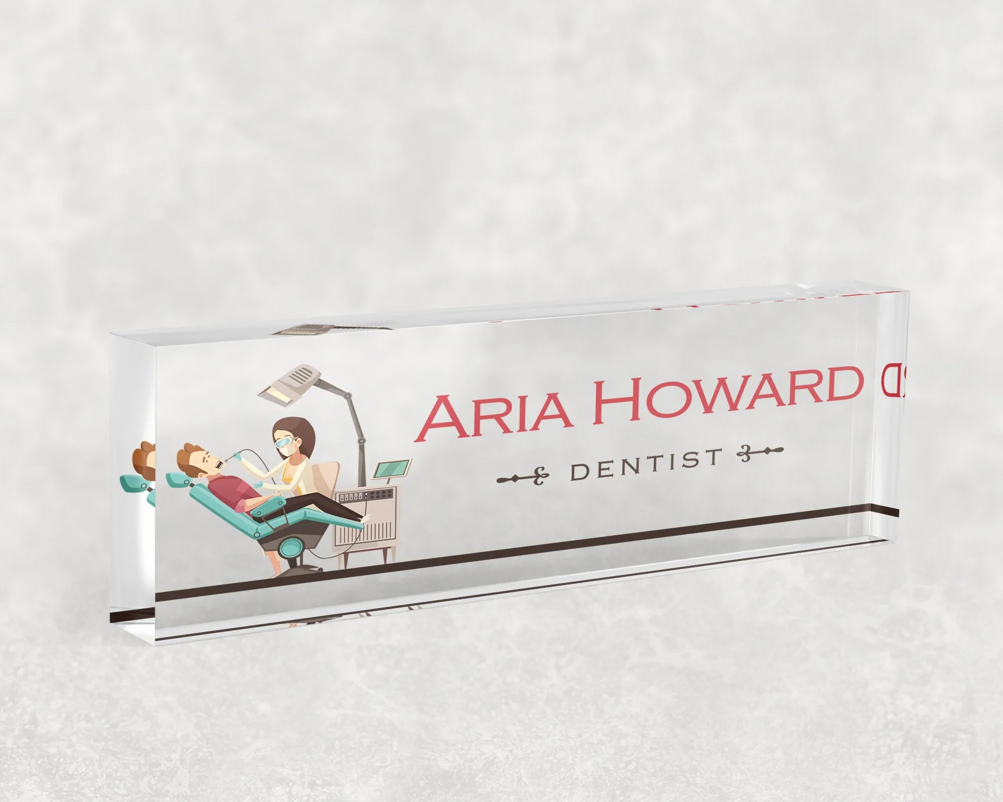 Studio view of a clear acrylic desk name plate with a dental chair illustration design