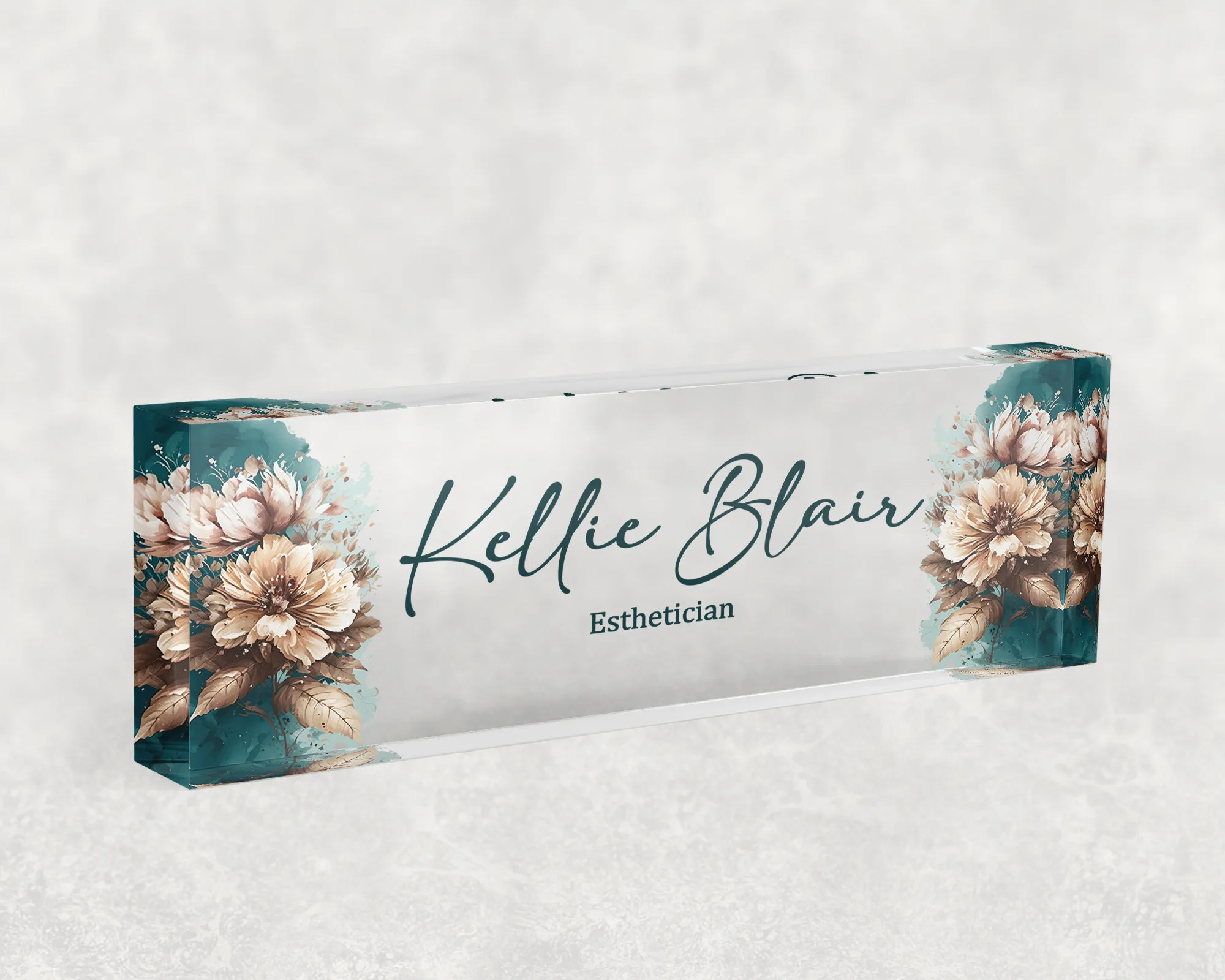 Studio view of a clear acrylic desk name plate with a teal and cream floral design