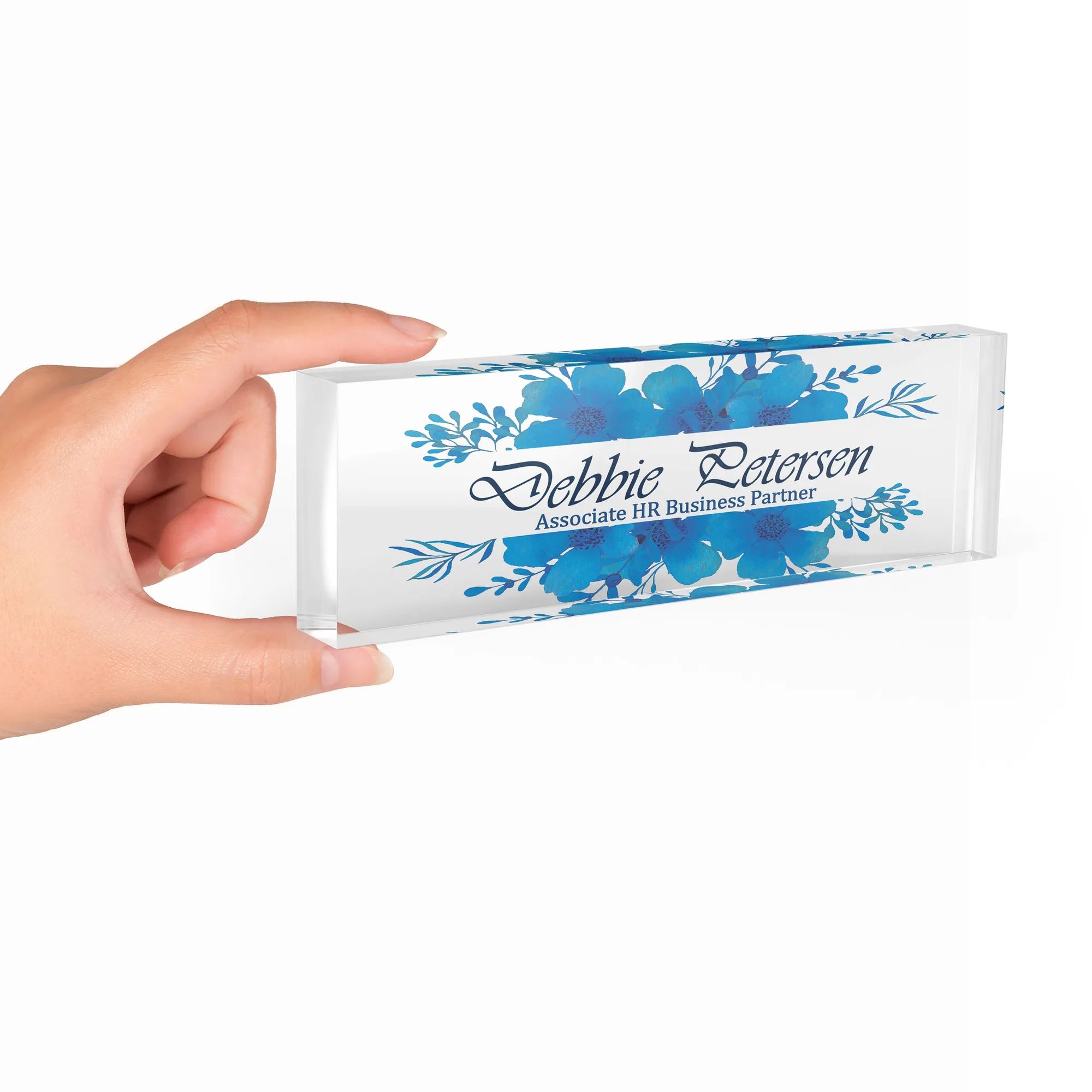 Hand holding a clear acrylic desk name plate with a blue watercolour floral design
