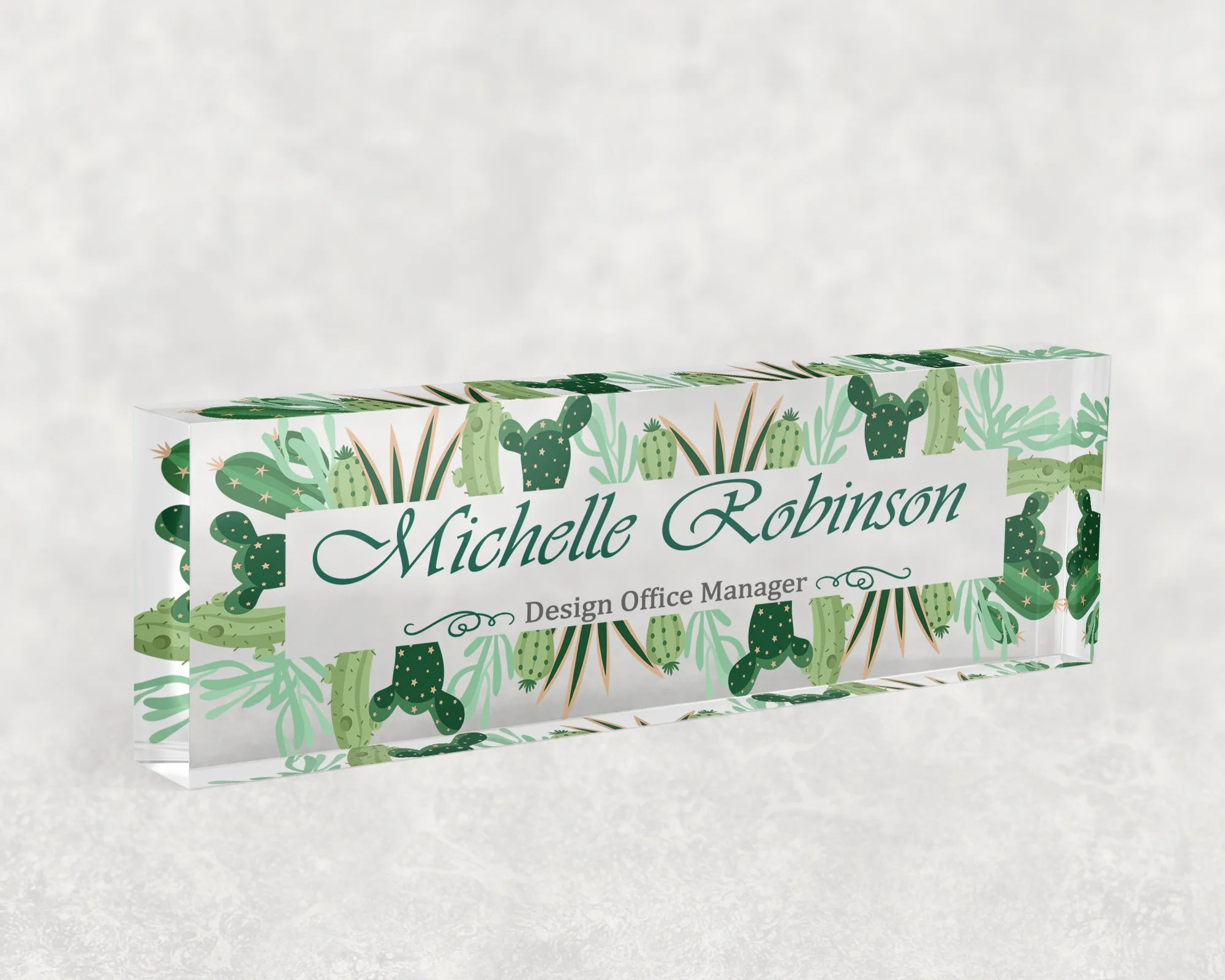 Studio view of a clear acrylic desk name plate with a cactus and succulent design