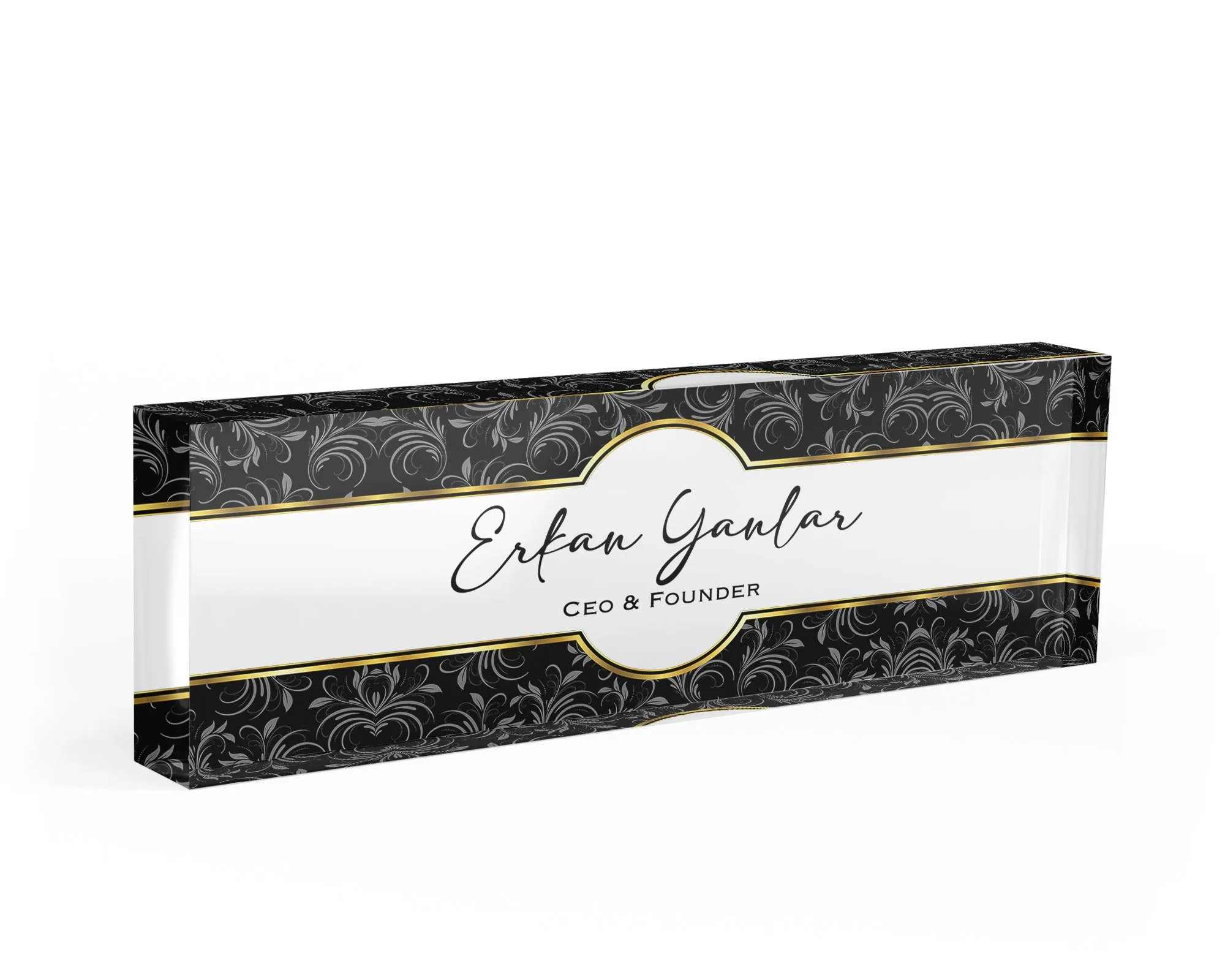 Studio view of a clear acrylic desk name plate with a black damask and gold design