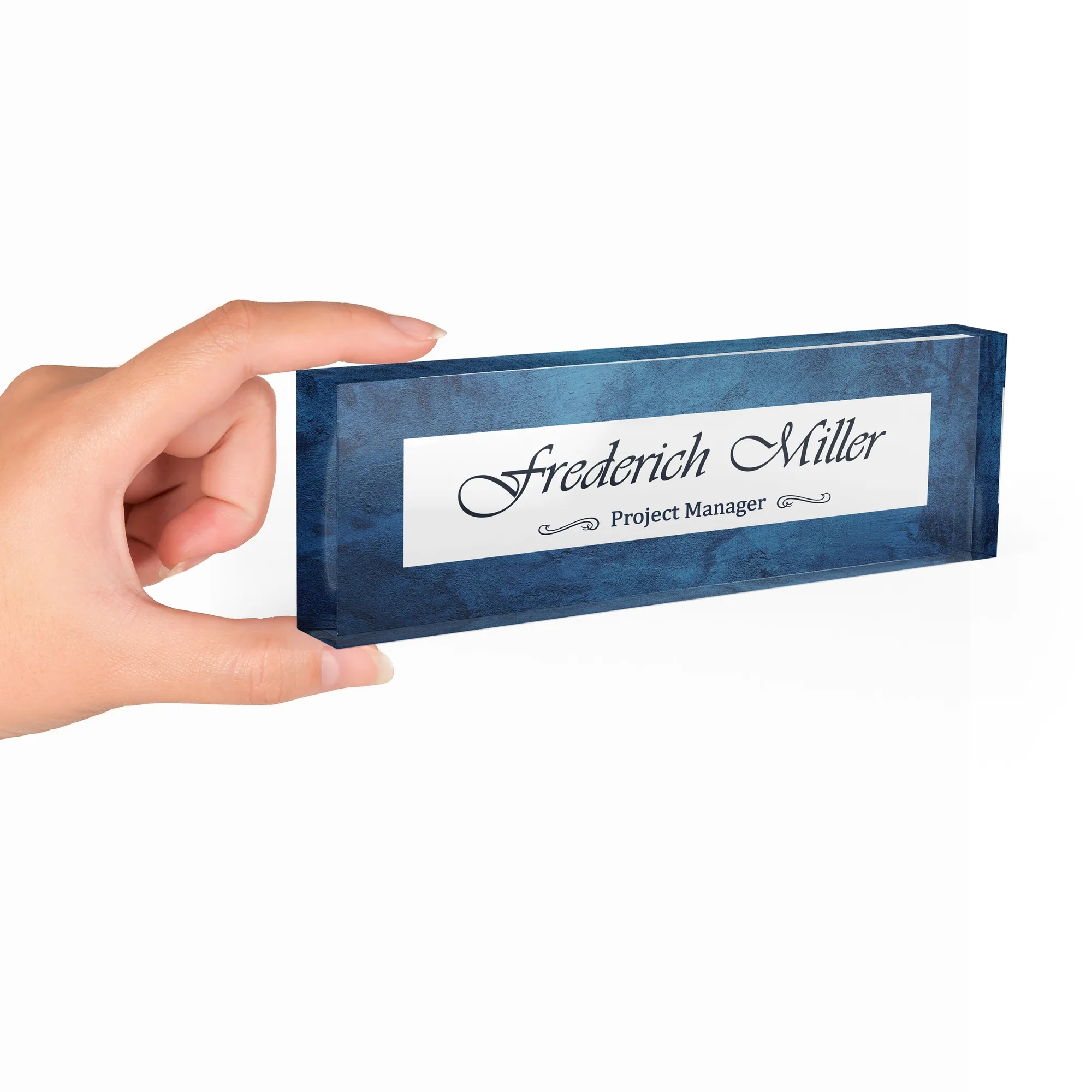 Hand holding a clear acrylic desk name plate with a navy blue ink wash design