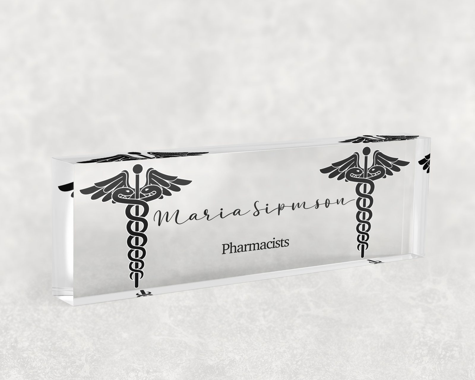 Black caduceus desk name plate in clear acrylic, personalized with a name and job title