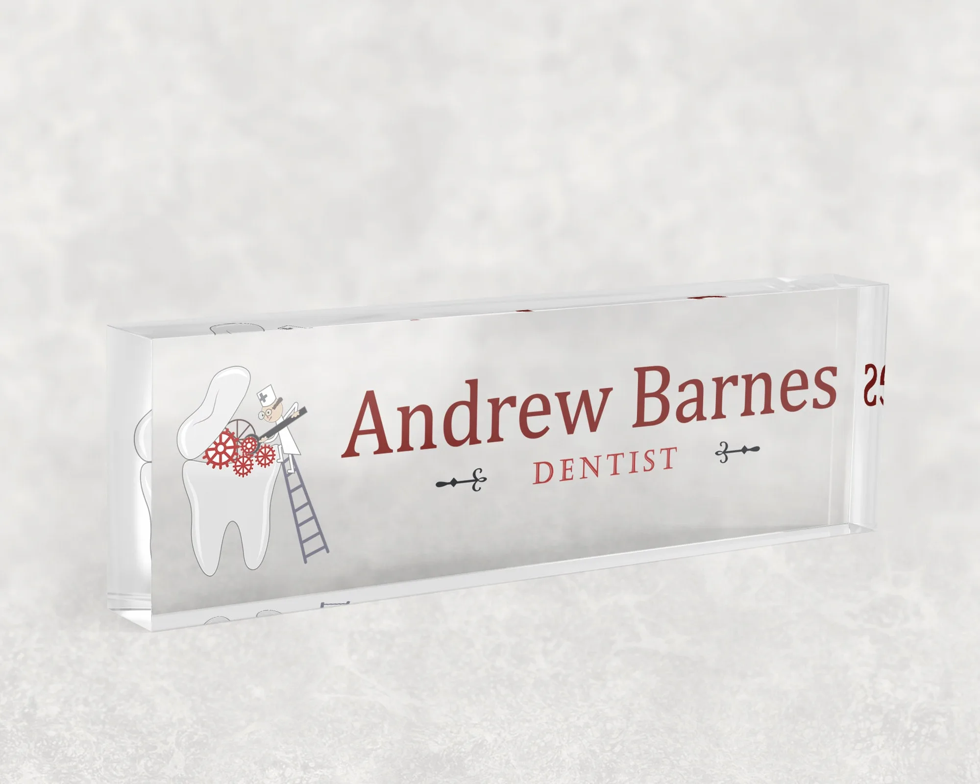 Studio view of a clear acrylic desk name plate with a dental tooth illustration design