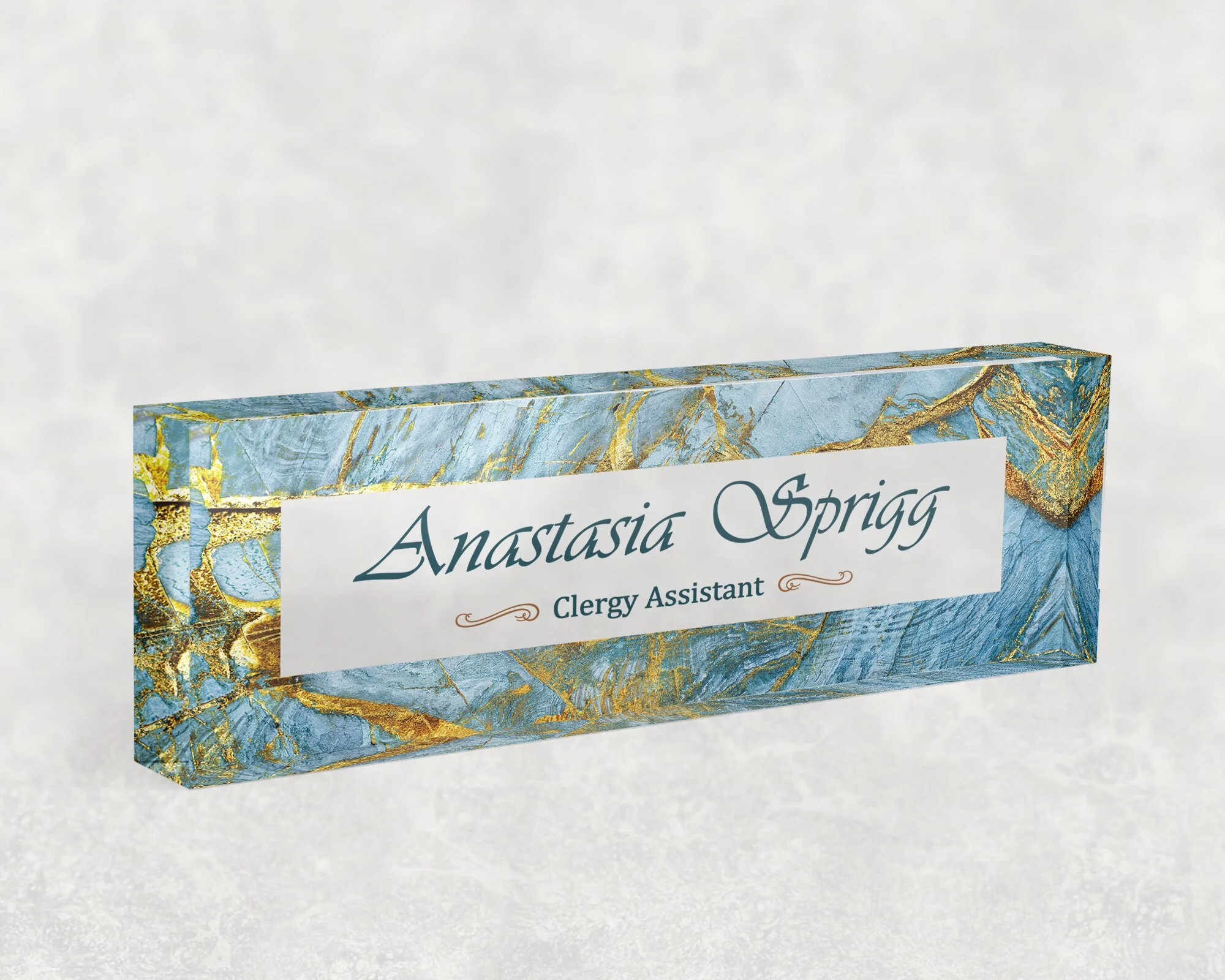 Studio view of a clear acrylic desk name plate with an azure marble and gold design