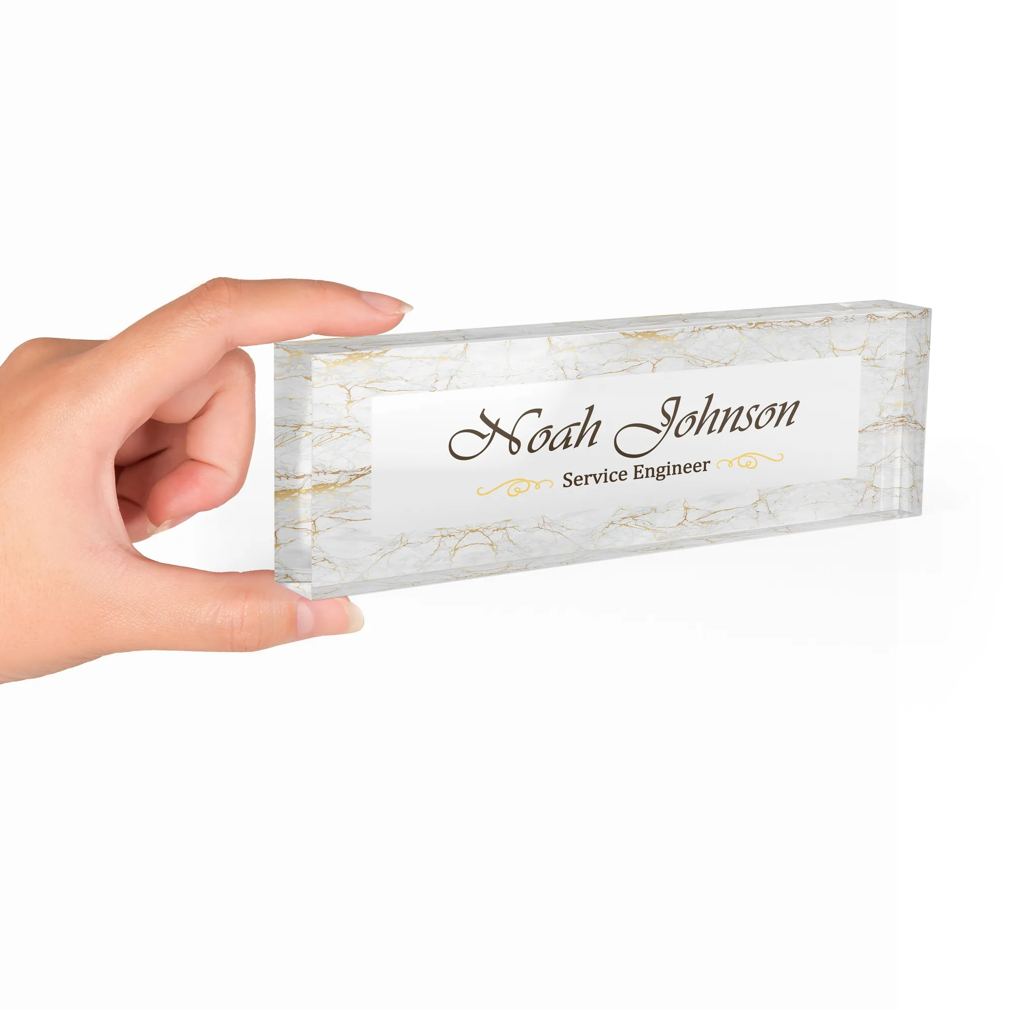 Hand holding a clear acrylic desk name plate with a white marble and gold design