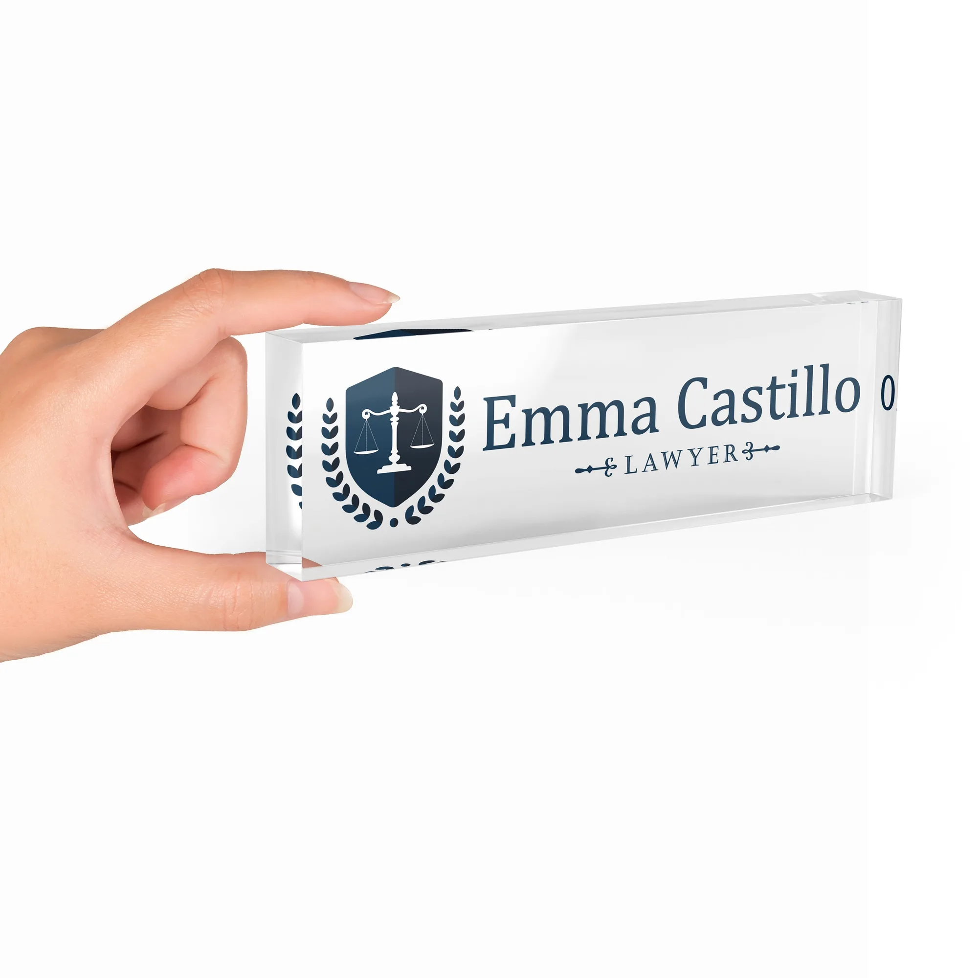 Hand holding a clear acrylic desk name plate with a navy justice shield design