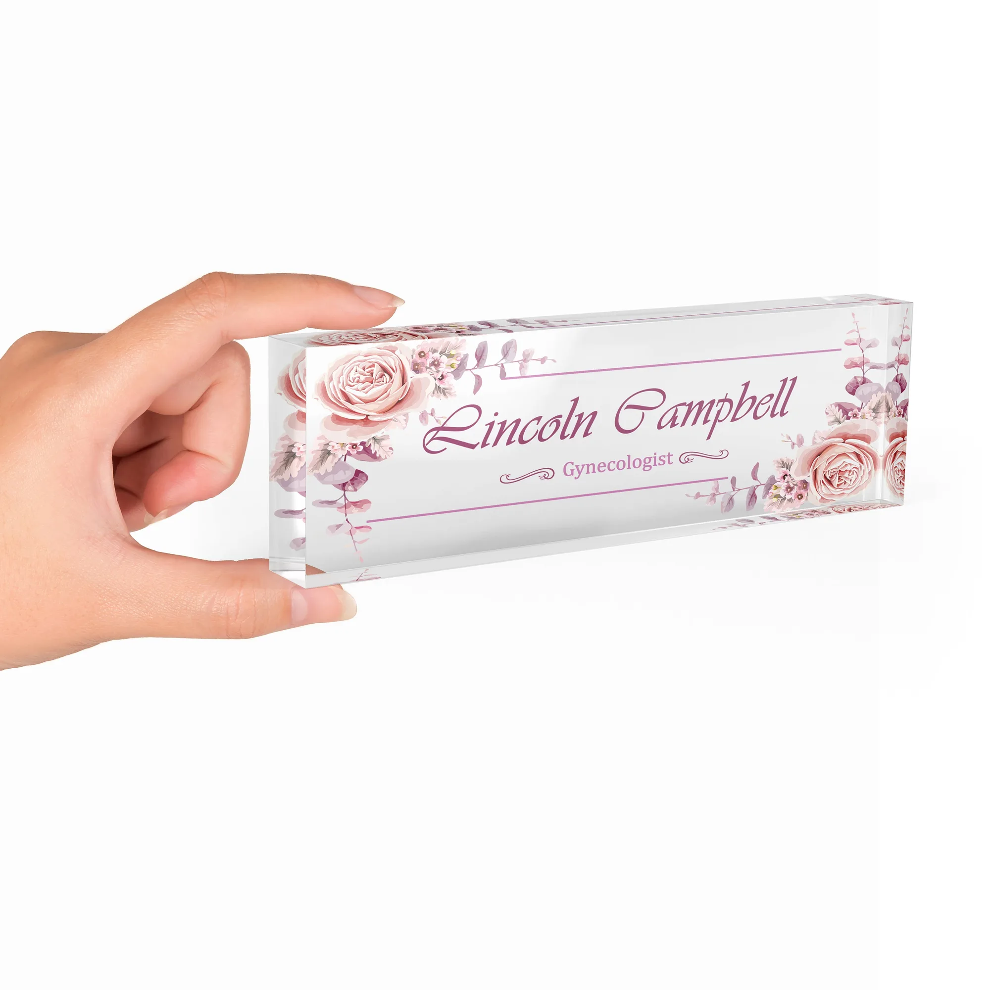 Hand holding a clear acrylic desk name plate with a blush pink rose design