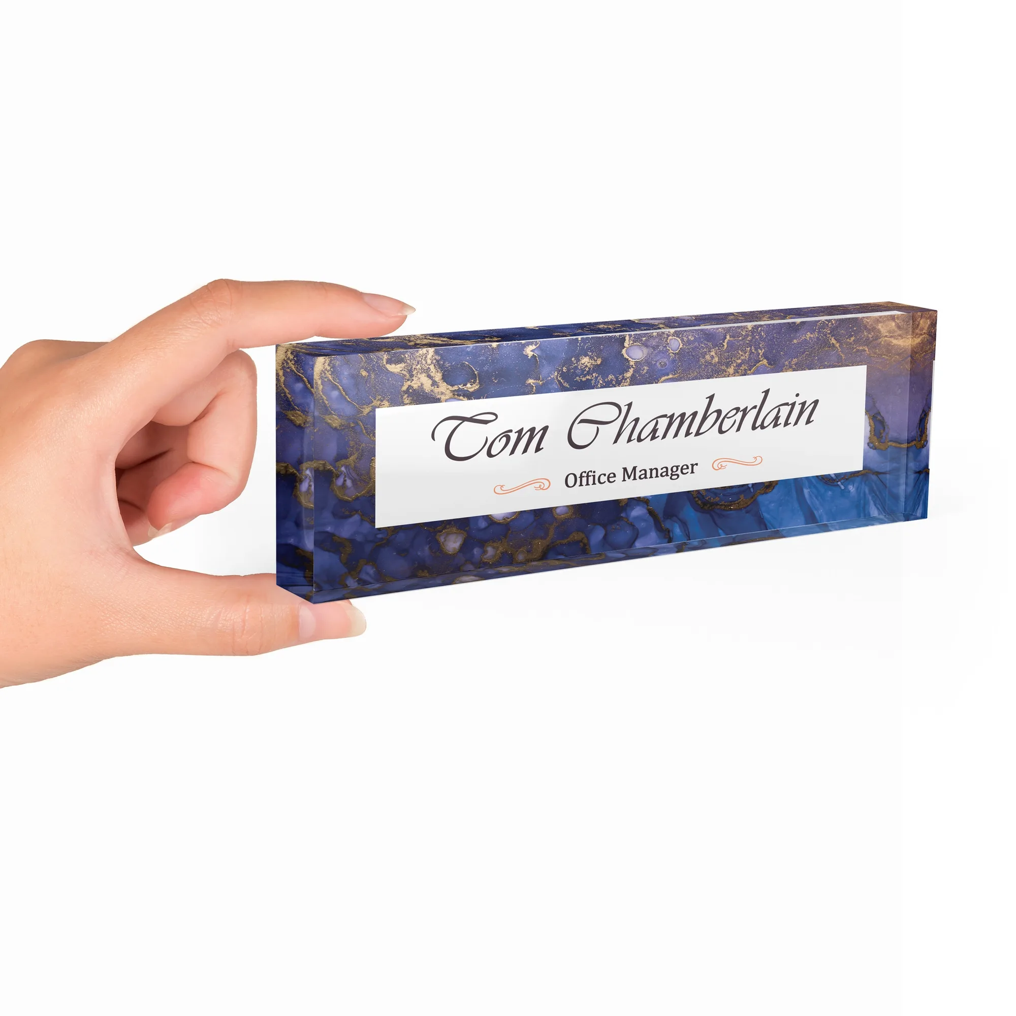 Hand holding a clear acrylic desk name plate with a navy agate design
