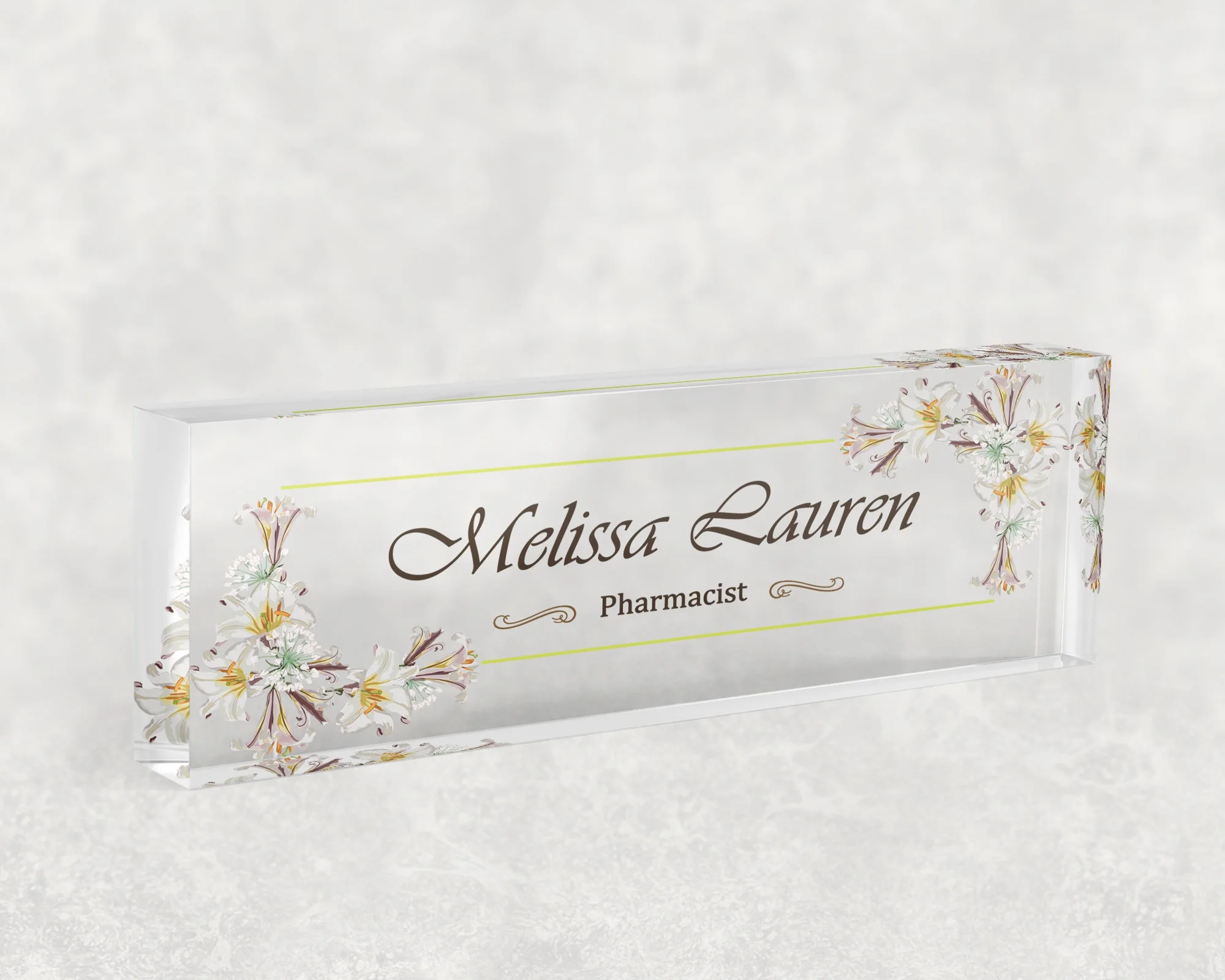 Studio view of a clear acrylic desk name plate with a cream daisy and gold line design