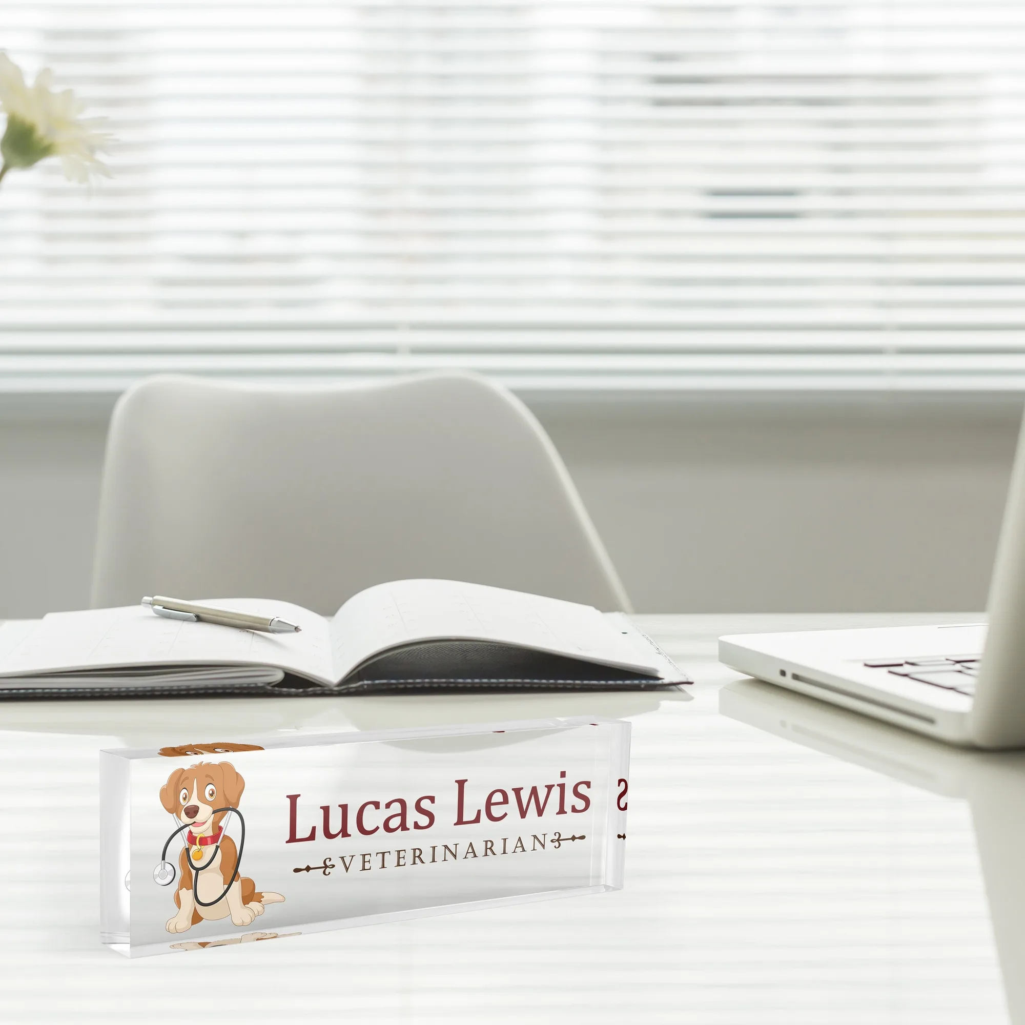 Acrylic desk name plate with a cartoon dog design beside an open notebook and a laptop