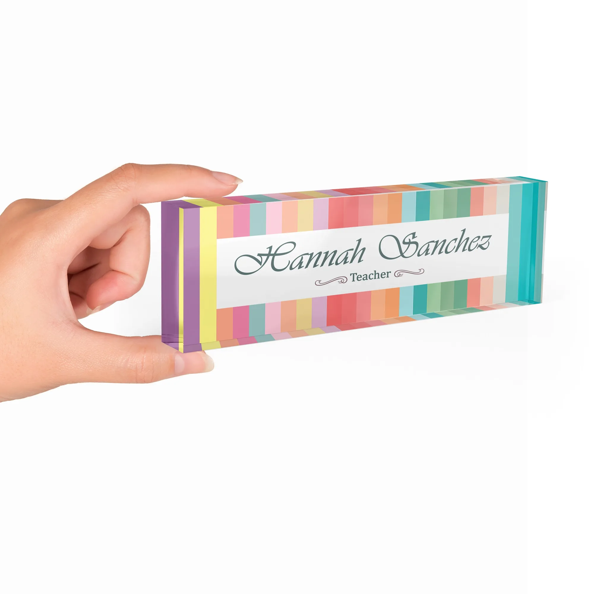 Hand holding a clear acrylic desk name plate with a bright rainbow stripe design