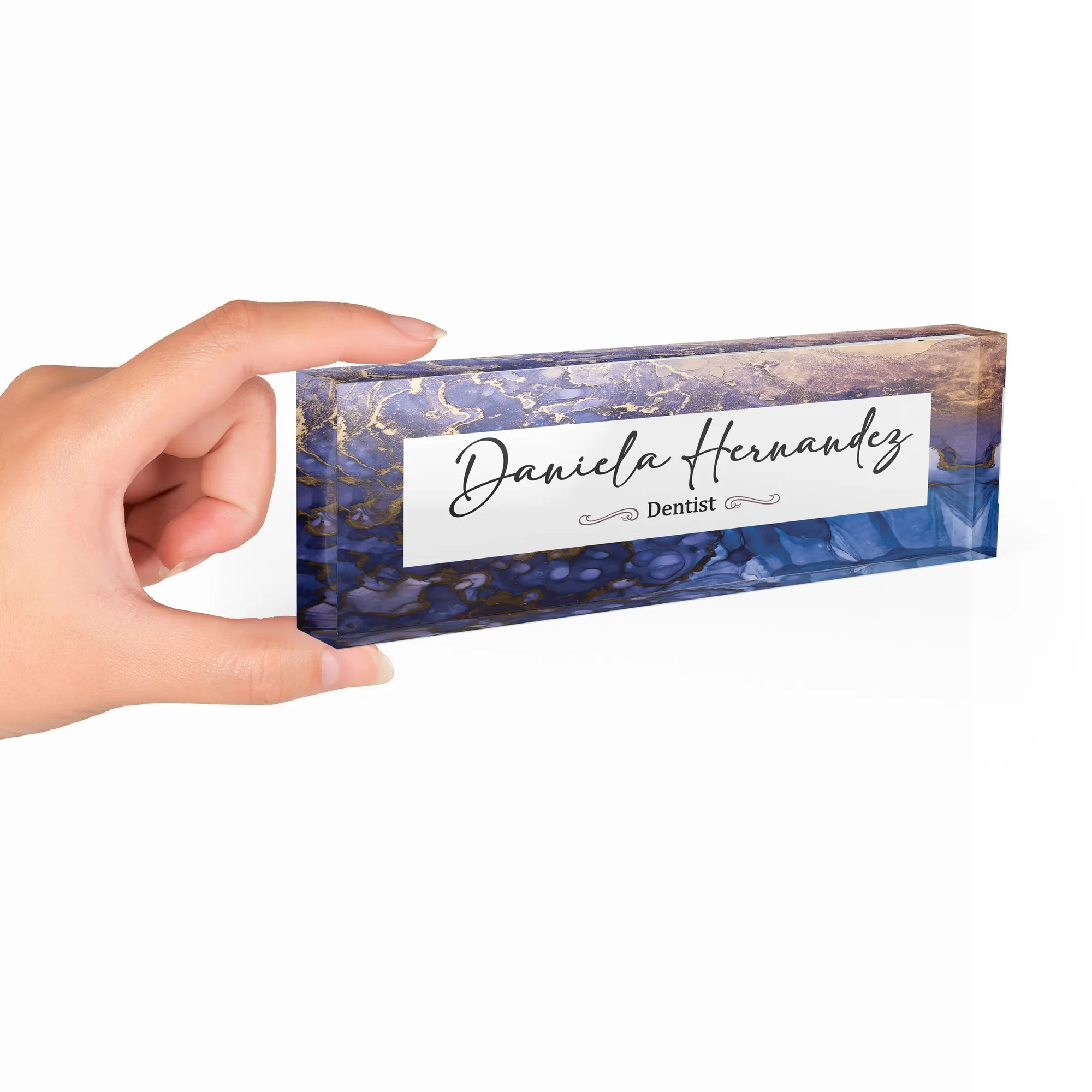 Hand holding a clear acrylic desk name plate with a violet and cobalt agate design