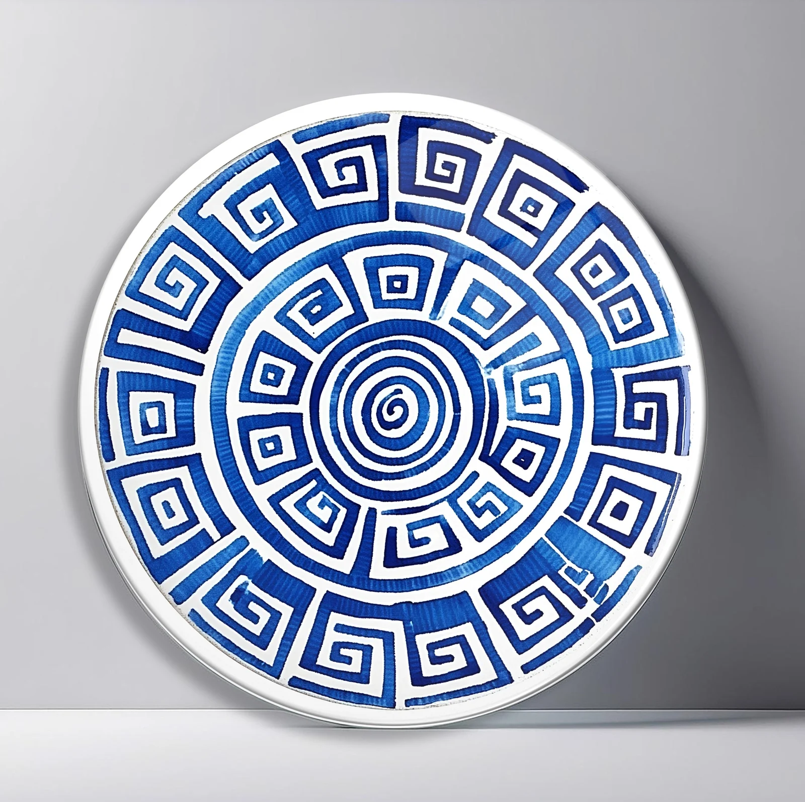 Blue Greek Spiral Round Glass Wall Art featuring bold cobalt Greek key pattern winding inward on white