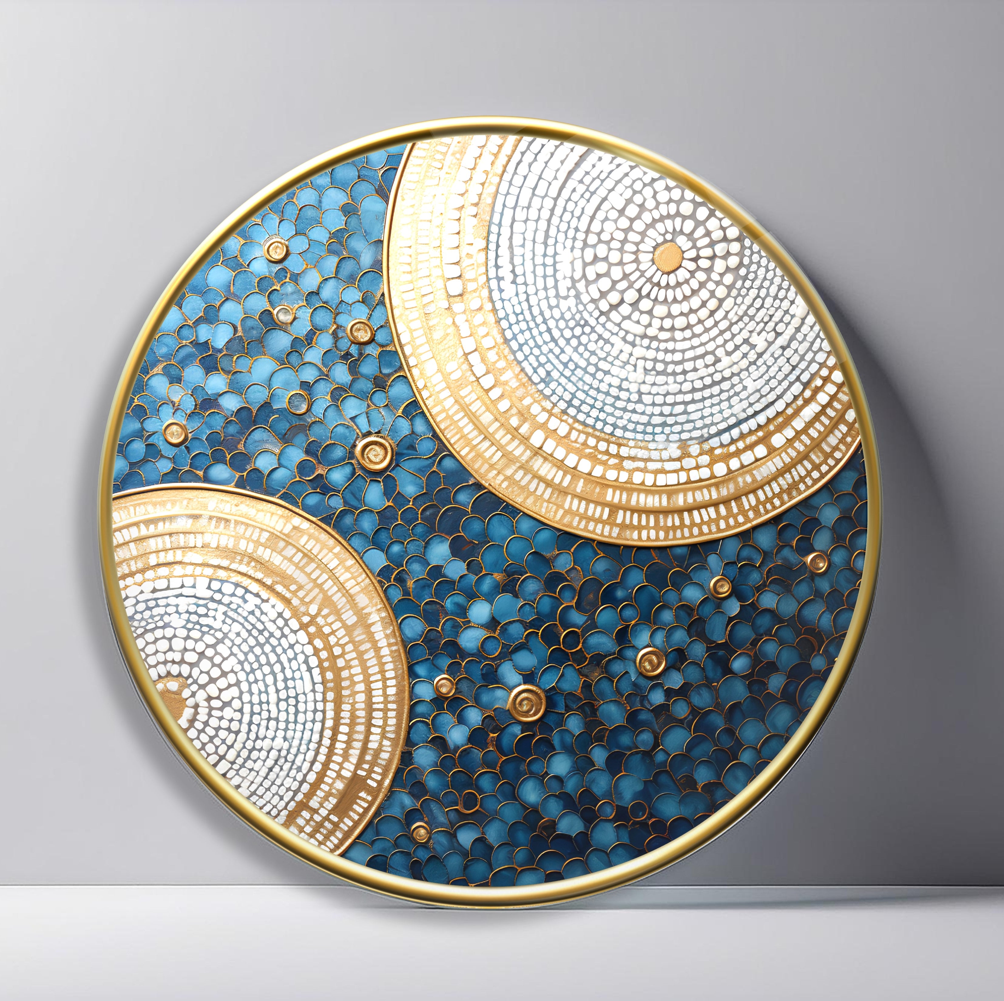 Golden Moons on Blue Pebbles Round Glass Wall Art featuring two overlapping gold and white circular mosaics floating over blue pebble texture