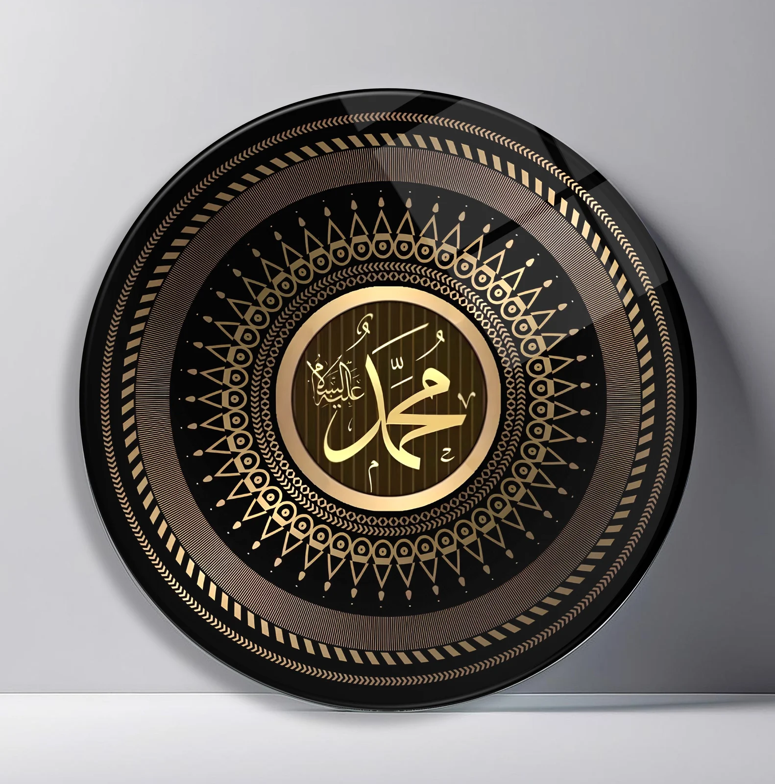 Prophet Muhammad Calligraphy Round Glass Wall Art featuring gold Arabic calligraphy of Muhammad centered in a geometric black medallion