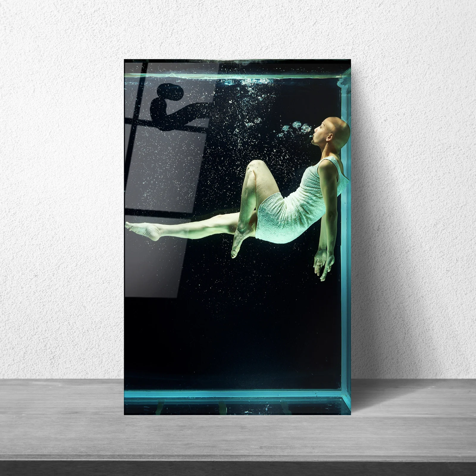 Woman floating underwater in dress glass wall art as a statement piece in a hallway