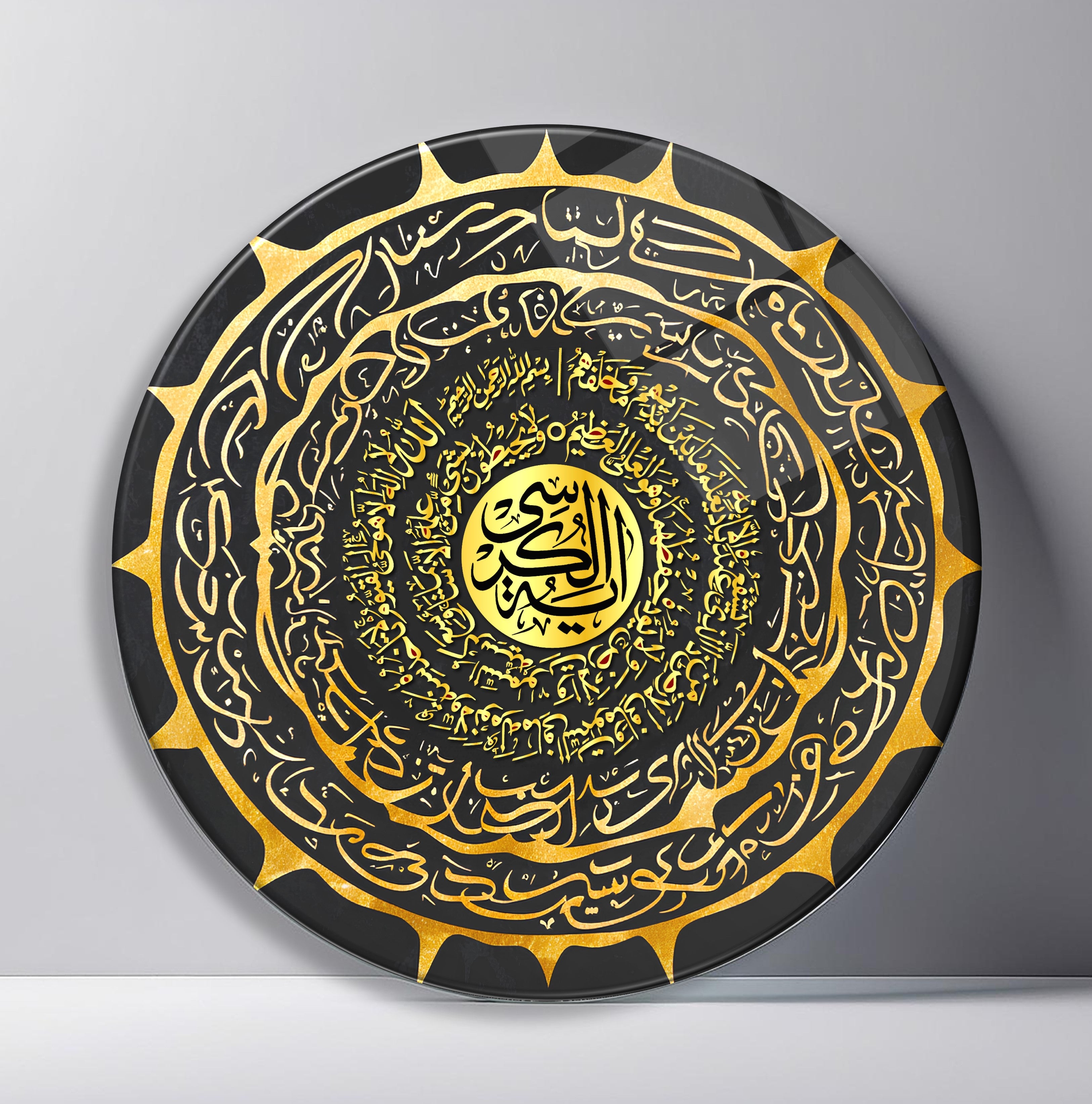 Black Gold Arabic Calligraphy Medallion Round Glass Wall Art front view, leaning against a neutral wall