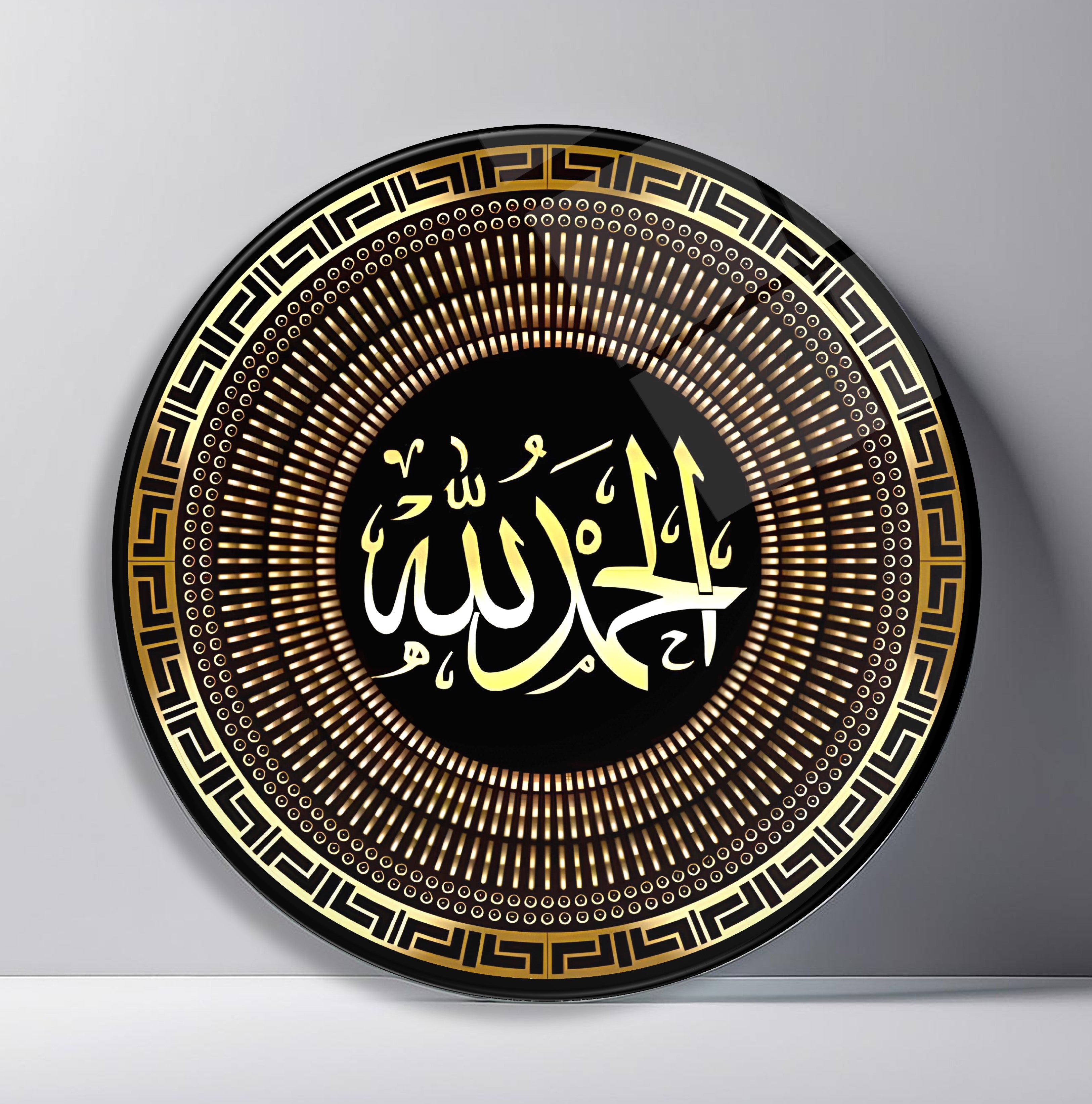 Alhamdulillah Black Gold Calligraphy Round Glass Wall Art front view, leaning against a neutral wall