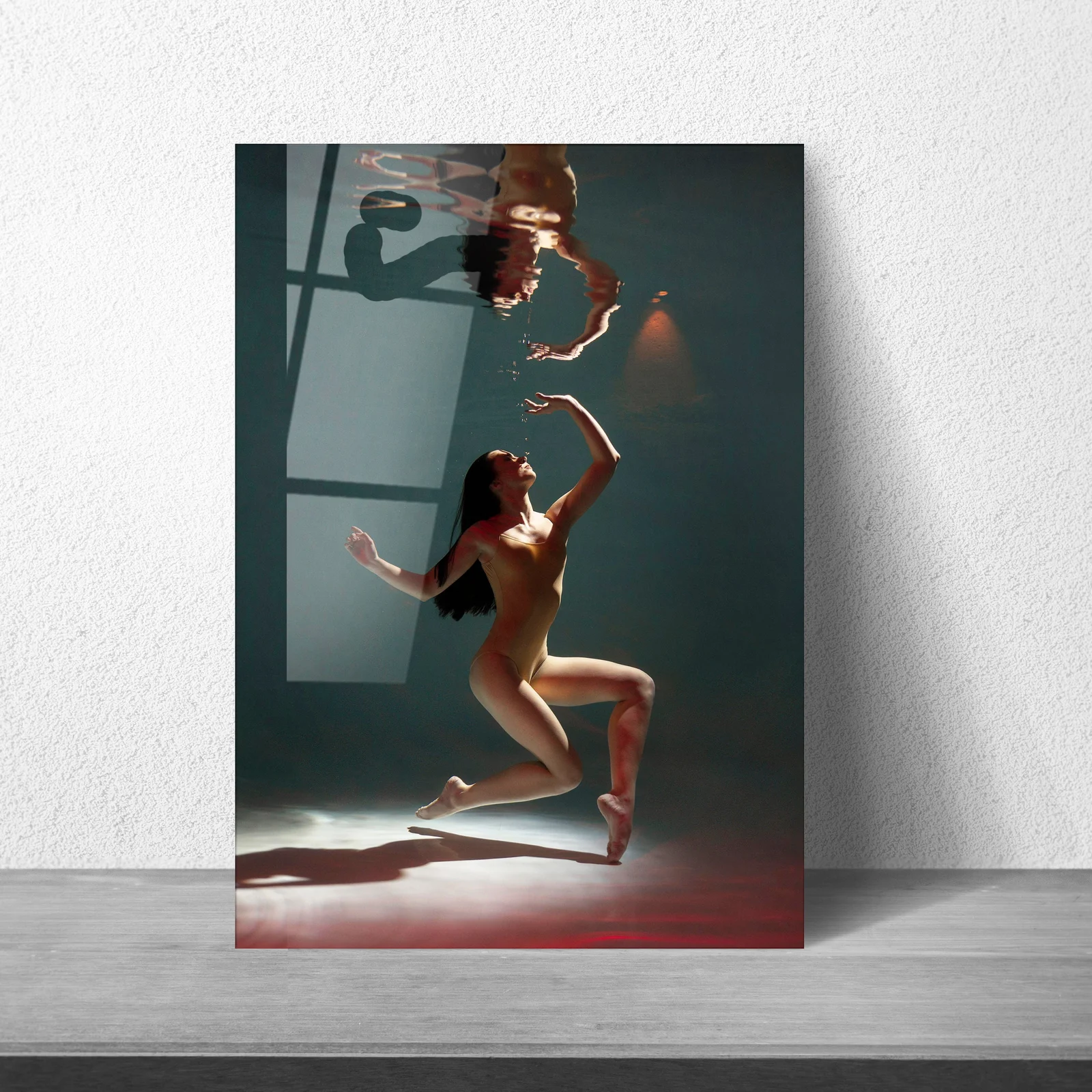Fine art underwater figure glass wall art displayed above a sofa