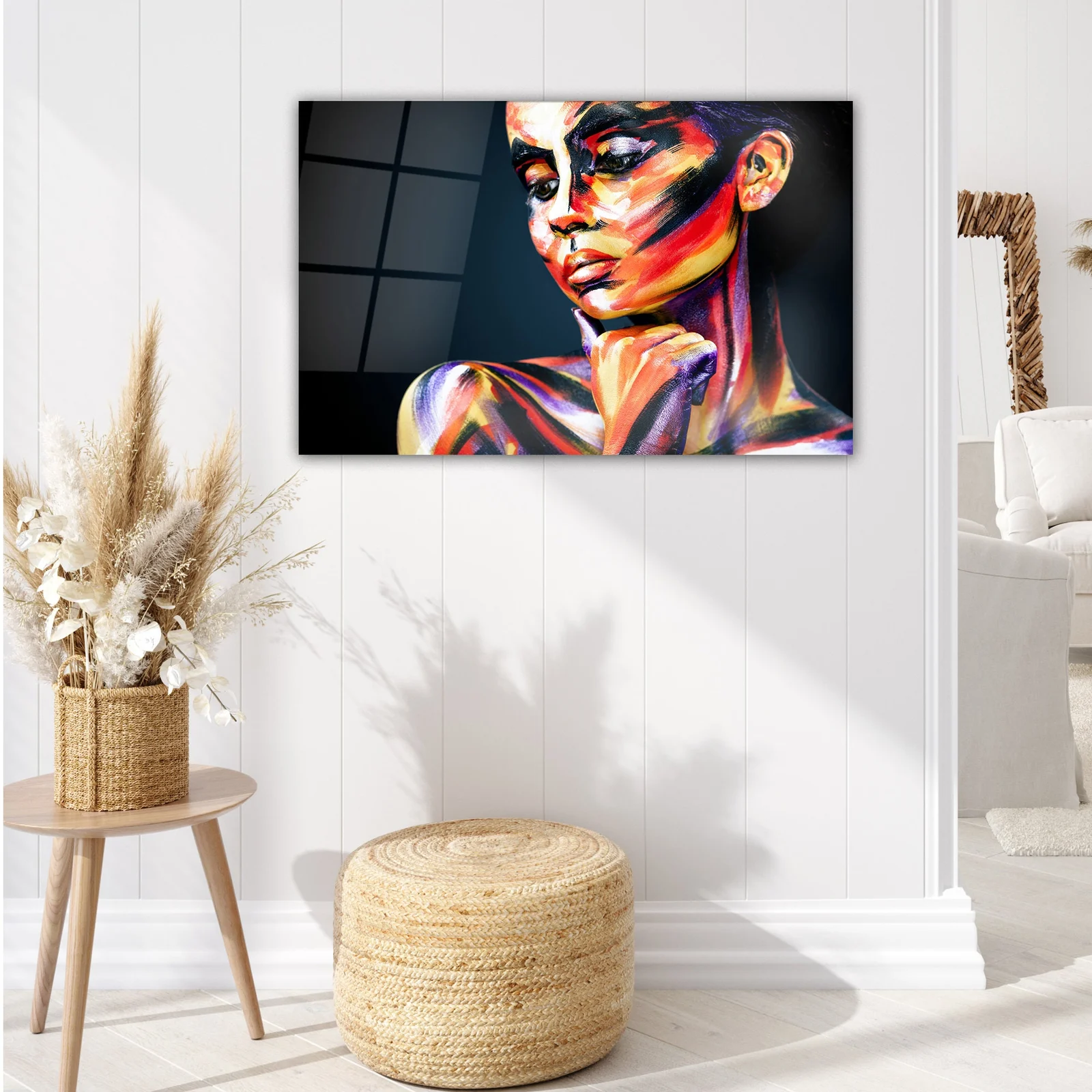Colorful body-paint portrait glass wall art displayed above a sofa